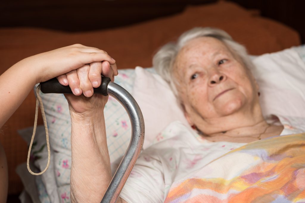 Elderly woman with walker sick in bed