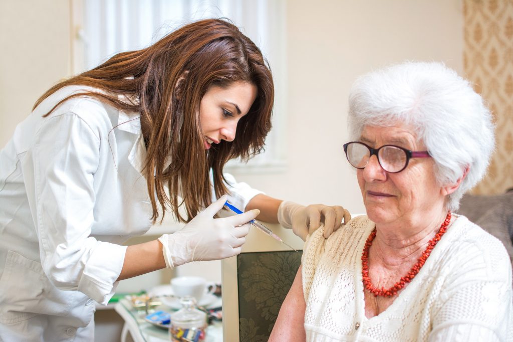 Elderly woman receiving Covid vaccine at home