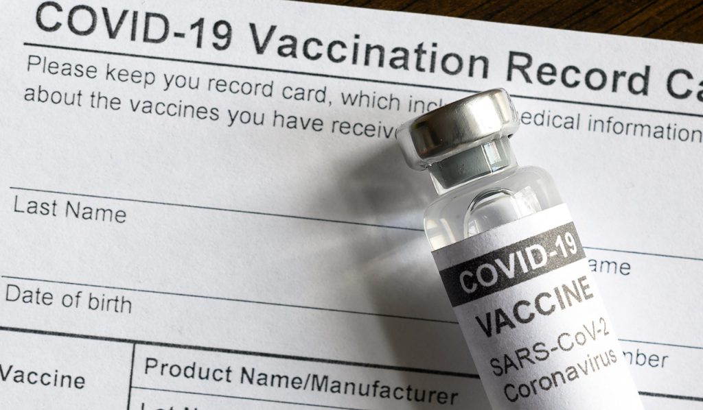 Covid-19 Vaccine Vial On Coronavirus Vaccination Record Card